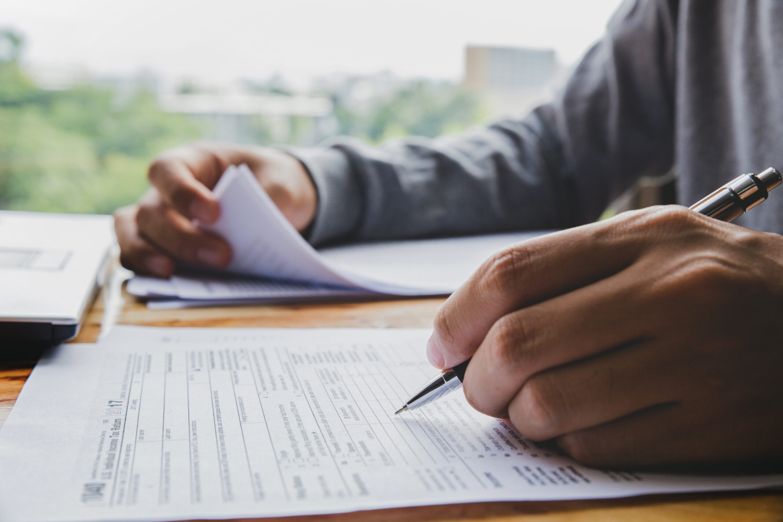 Closeup of man hand filling income tax forms