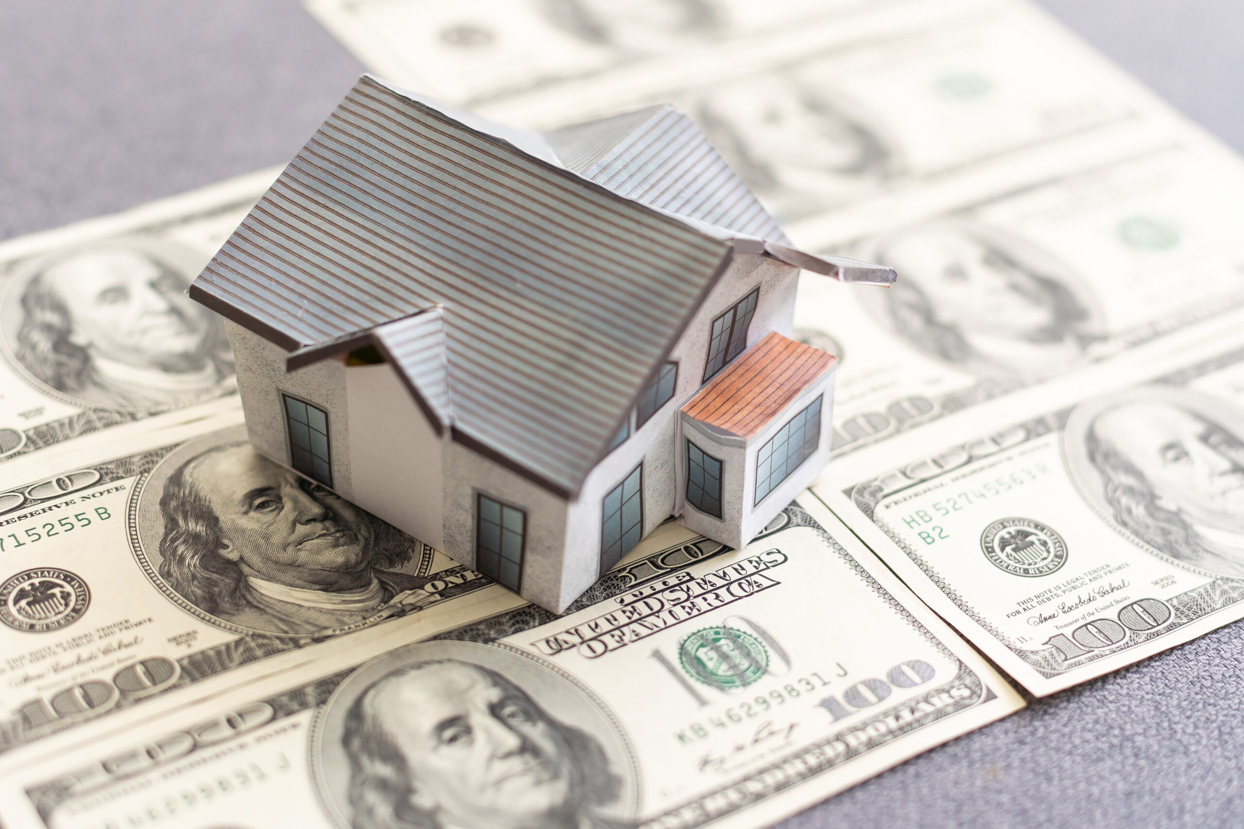 Miniature house with money on tax papers. High quality photo